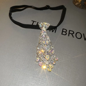 Detailed view of tie-shaped pendant necklace with rhinestones and adjustable black strap