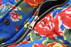Macro detail of high-quality metal zipper and snap button on floral print jacket