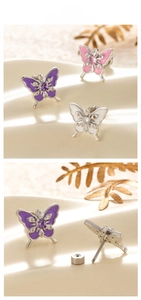 Detail of titanium steel butterfly ear studs with enamel and purple zircons in close-up