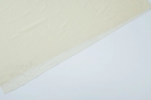 Detailed close-up of high-density knit mesh fabric texture in light yellow beige tone