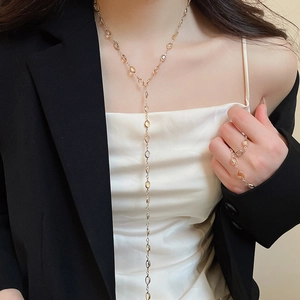 Close-up of model wearing gold Y-shaped resin fringe necklace and matching ring set