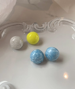Détails de boucles d'oreilles boules en émail avec motifs en spirale bleus et blancs