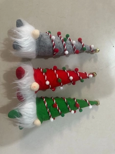 Close-up of three festive Christmas gnomes with colorful felt hats and golden bells