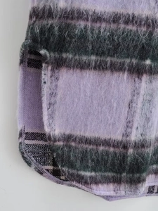 Detail of purple plaid woolen coat featuring soft long-hair texture and side slit design