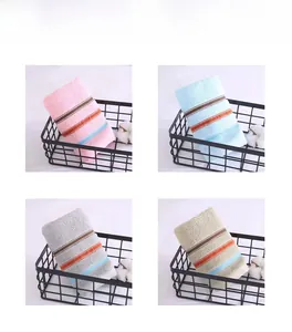 Detail view of four-color striped cotton towels in a black iron basket with cotton accents