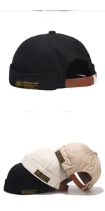 Detail view of canvas docker caps in black and khaki with adjustable leather strap