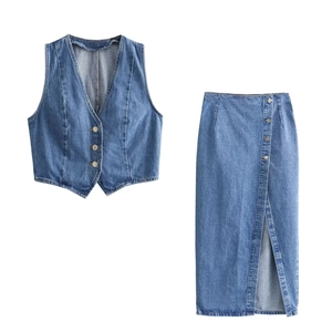 Completo due pezzi in denim con gilet con scollo a V e gonna midi a spacco su sfondo bianco