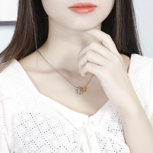 Close-up of elegant interlocking silver and gold rings necklace with pavé stones on a model