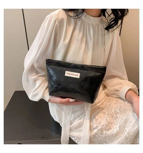 Close-up of black textured cosmetic bag with Fashion Bag label on white sleeve