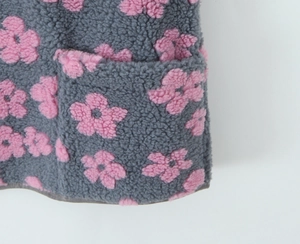 Close-up of soft grey fleece fabric with pink floral print and functional side pocket