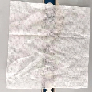 Close-up of unfolded white disposable compressed towel with textured mesh pattern