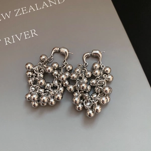 Vue détaillée des boucles d'oreilles boules argentées avec finition polie sur un livre