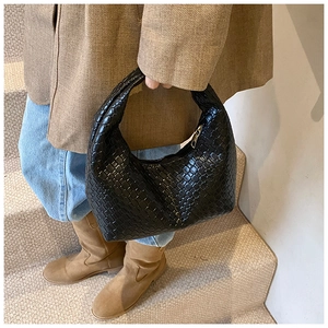 Close-up of black woven hobo handbag with metal zipper and premium Intrecciato texture