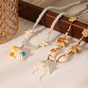 Detailed shot of starfish and shell pendants on pearl and woven bead necklaces