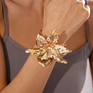 Dettaglio macro di un bracciale a polsino a fiore dorato con texture di petali realistici