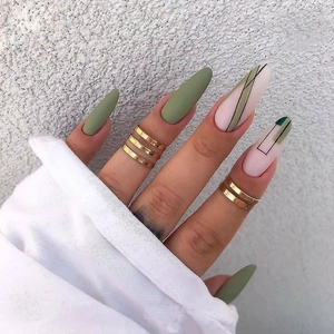 Detail of long almond press-on nails in dark green and nude pink with geometric lines