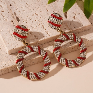 Detail of gold earrings with red enamel stripes and sparkling crystals on stone base