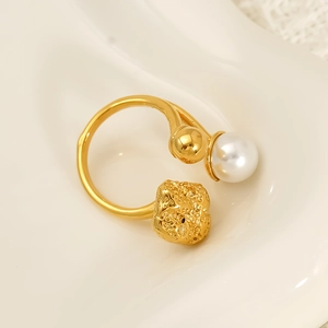 Adjustable golden ring featuring a white pearl and irregular lava texture sphere detail