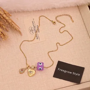 Golden bead necklace with evil eye charm, feather pendant, and heart crystal in retro style