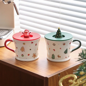 Detail of Christmas ceramic mugs with Santa Claus and Christmas tree lid toppers