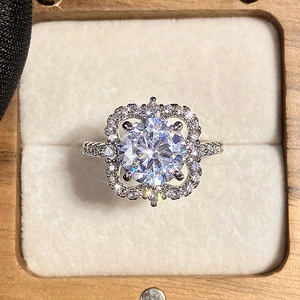 Luxe bloemen verlovingsring met ronde hoofddiamant en pavé gezette zilveren band