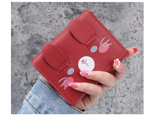 Close-up of a red PU leather wallet with cute rabbit ears held by a hand