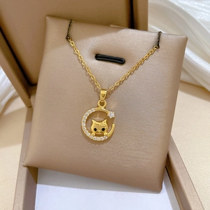 Macro view of golden crescent moon pendant with black cat and sparkling zircon crystals