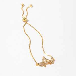 Detail of adjustable gold butterfly bracelet with white zircon pave setting on white background