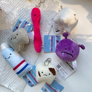 Macro view of plush dental charms including toothbrush and toothpaste on textured paper