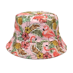 Close-up of pink bucket hat with flamingo, pineapple and tropical leaf print fabric details
