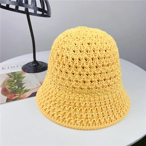 Detail of a bright yellow hollow weave sun hat with breathable knit pattern and texture