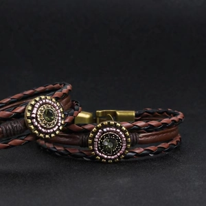 Multilayer braided leather bracelet with bronze clasp and green gemstone centerpiece