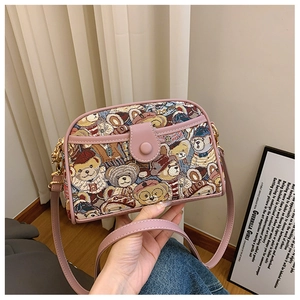 Detail of cute pink canvas crossbody bag featuring colorful cartoon bear pattern textures