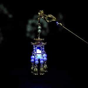 Detailed close-up of a golden vintage hairpin with a blue LED lantern and white pearls