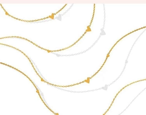 Detalle del delicado collar dorado con colgantes de corazón y eslabones refinados