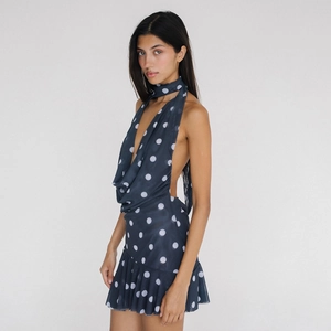 Détail de la robe courte à pois bleu marine avec dos nu et ourlet à volants