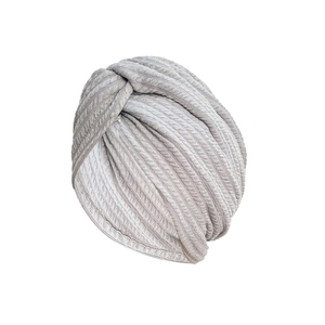 Close-up of light gray twisted turban hat with thick waffle knit texture and elastic fabric