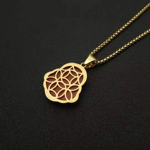 Detail of gold-plated Buddha pendant with red cat's eye stone on a round box chain