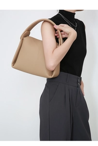 Detail view of the khaki pebbled leather texture and wide shoulder strap of the handbag