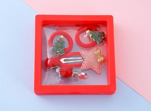 Detailed view of Christmas hair accessories set with elk and tree in a red display box