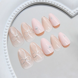 Pink cat eye pearl bow press-on nails with 3D star patterns and silver floral accents