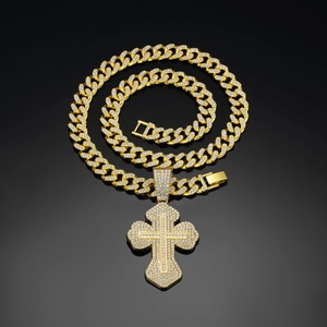 Close-up of golden iced-out Cuban chain necklace with large rhinestone cross pendant