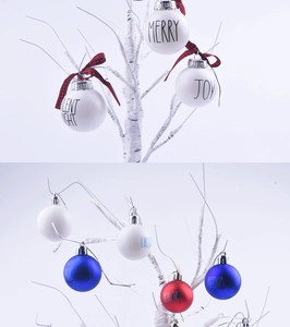 Detail of Christmas and holiday ornaments with festive text prints on white branches