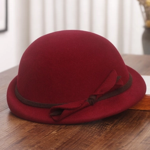 Detailed view of wine red wool beret with dark brown ribbon and side bow accent