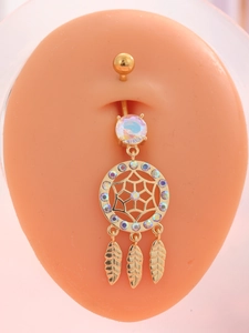 Detail of dreamcatcher belly button ring with zircon stones on a model skin base