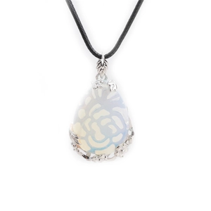 Macro shot of opal water drop pendant featuring silver floral carvings and black cord