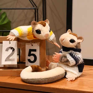 Realistic sugar glider plush toys wearing colorful knitted sweaters on a wooden desk