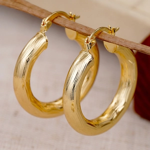 Elegante Creolen aus 18K Gold mit gehämmerter Metalloberfläche und unregelmäßiger Textur