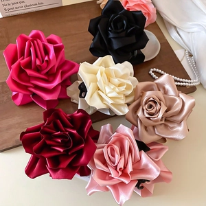 Gros plan de pinces à cheveux rose en soie en six couleurs sur un plateau avec des perles