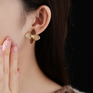 Close-up of vintage floral stud earring with brown resin petals on a model's ear